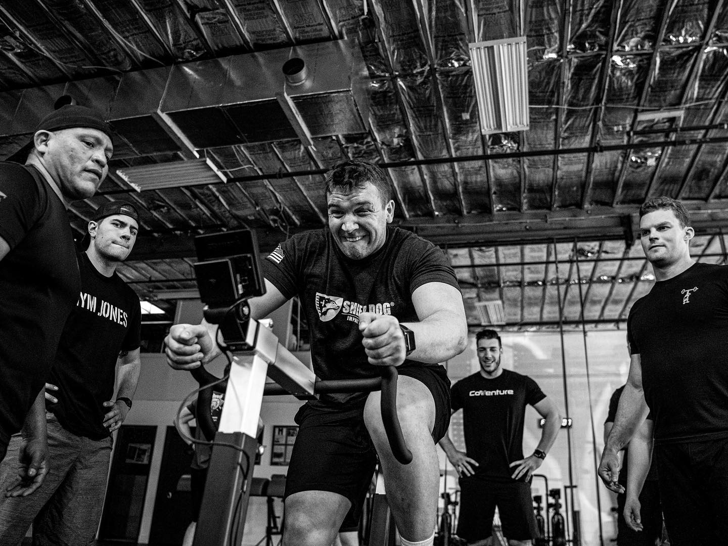 A man on a bike being cheered on by peers.