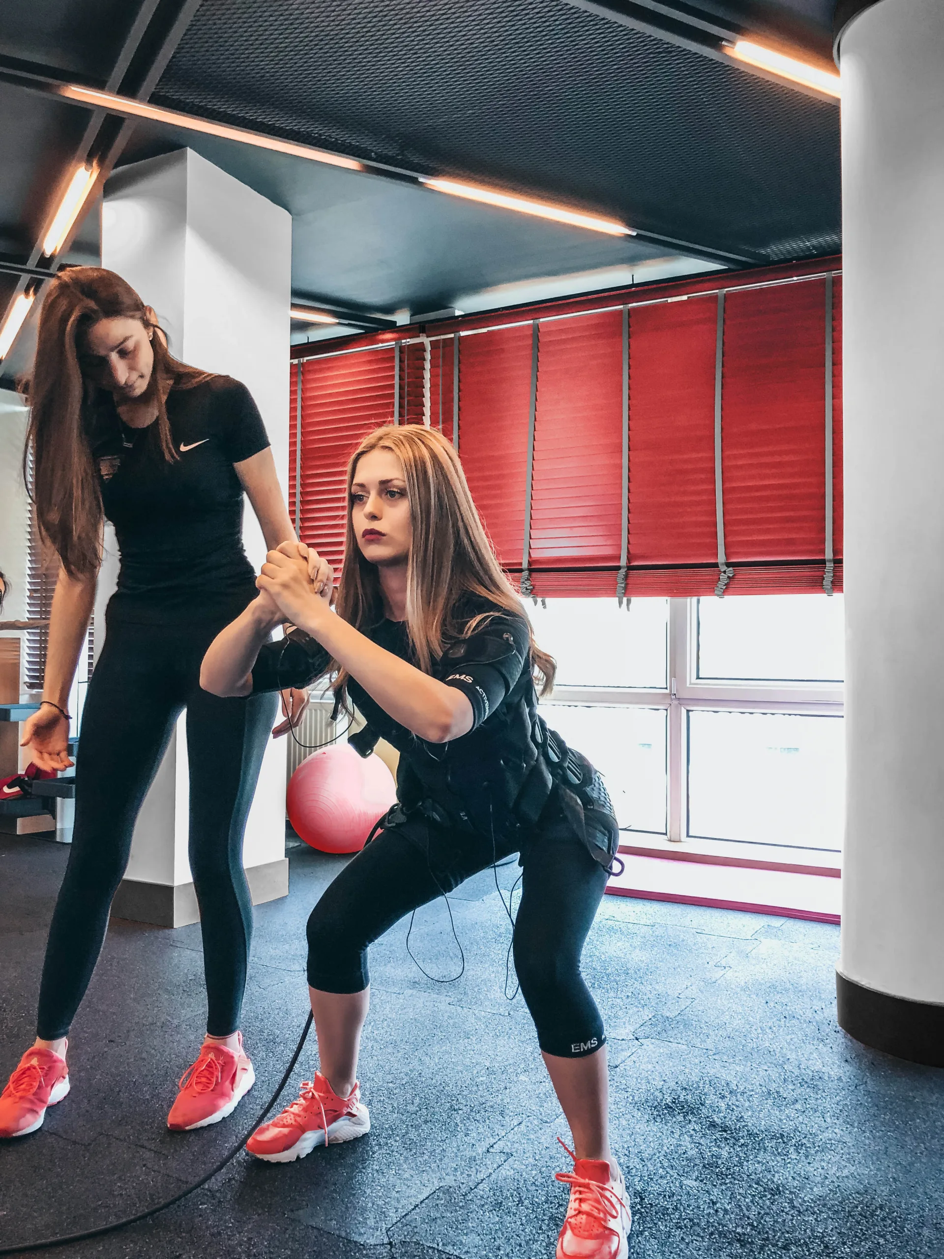 A personal trainer helping someone workout.